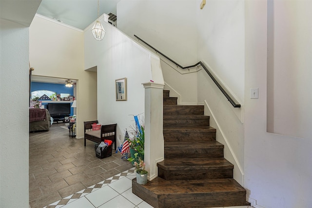 staircase with tile patterned flooring and a towering ceiling