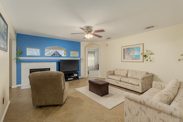2103 Laurel Arbor Dr, Houston, TX 77014 - living area with a ceiling fan, a tile fireplace, tile patterned floors, and arched walkways