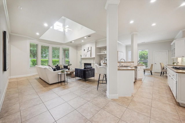 5638 Ballina Canyon Ln, Houston, TX 77041 - kitchen featuring a sink, crown molding, light tile patterned floors, open floor plan, and white cabinetry