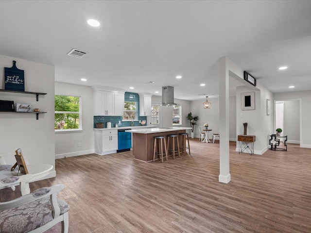5225 Main St, Santa Fe, TX 77510 - kitchen with a kitchen island, island exhaust hood, visible vents, light countertops, and dishwashing machine