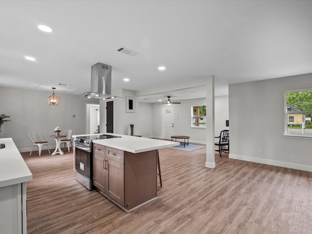 5225 Main St, Santa Fe, TX 77510 - kitchen with stainless steel electric range, visible vents, island range hood, and light wood finished floors