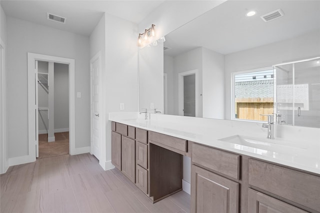 1904 Golden Spruce Ln, Conroe, TX 77301 - bathroom featuring visible vents, a sink, double vanity, and a shower stall