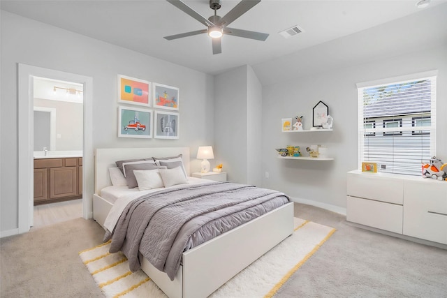 1904 Golden Spruce Ln, Conroe, TX 77301 - bedroom featuring a ceiling fan, visible vents, baseboards, ensuite bathroom, and light carpet
