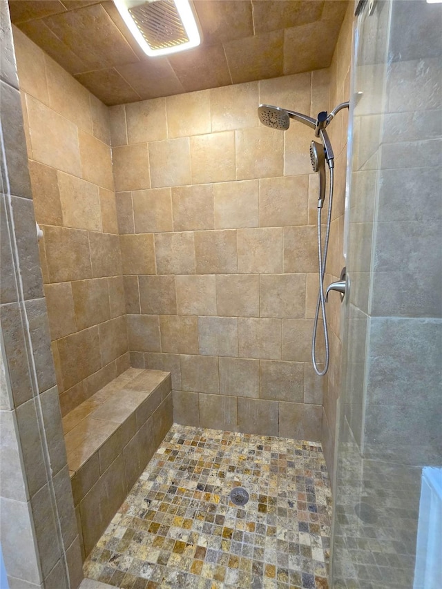 bathroom with a tile shower and visible vents
