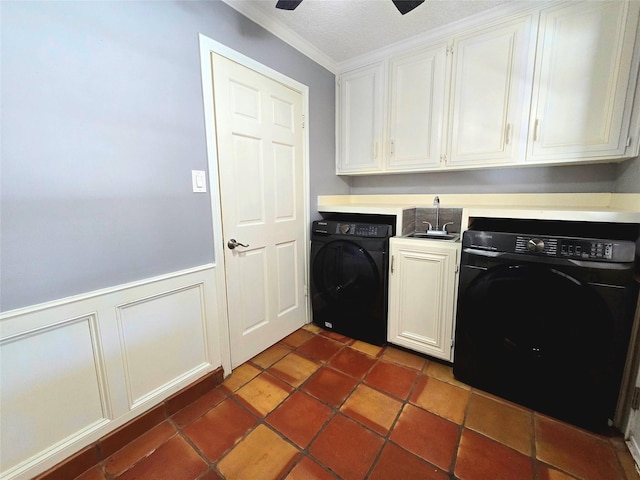 washroom with a sink, a wainscoted wall, crown molding, and cabinet space