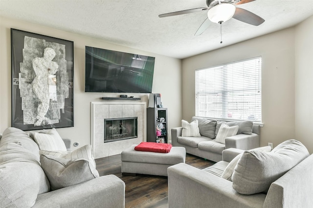 9322 Colt Canyon Ln, Houston, TX 77089 - living area featuring wood finished floors, ceiling fan, a tiled fireplace, and a textured ceiling