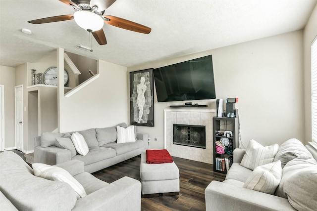 9322 Colt Canyon Ln, Houston, TX 77089 - living area featuring dark wood-style floors, ceiling fan, stairway, a tiled fireplace, and a textured ceiling