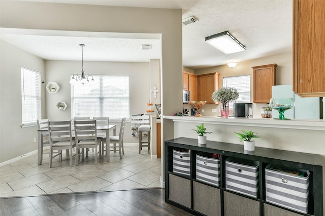 9322 Colt Canyon Ln, Houston, TX 77089 - kitchen featuring stainless steel microwave, plenty of natural light, a chandelier, and refrigerator