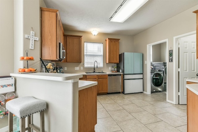 9322 Colt Canyon Ln, Houston, TX 77089 - kitchen featuring stainless steel appliances, washer / clothes dryer, light countertops, and a peninsula