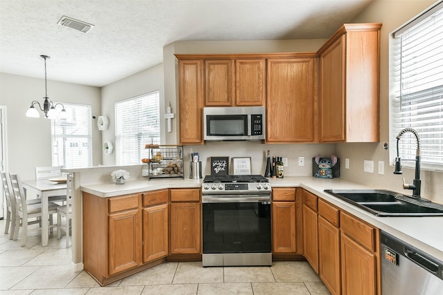 9322 Colt Canyon Ln, Houston, TX 77089 - kitchen with appliances with stainless steel finishes, a peninsula, light countertops, a chandelier, and light tile patterned flooring