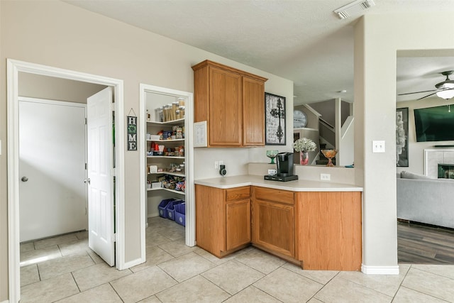 9322 Colt Canyon Ln, Houston, TX 77089 - kitchen with light countertops, a ceiling fan, light tile patterned flooring, and brown cabinetry