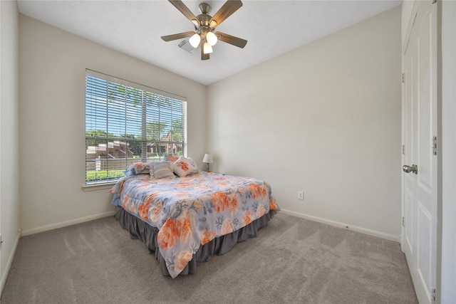 carpeted bedroom featuring baseboards, a ceiling fan, and visible vents