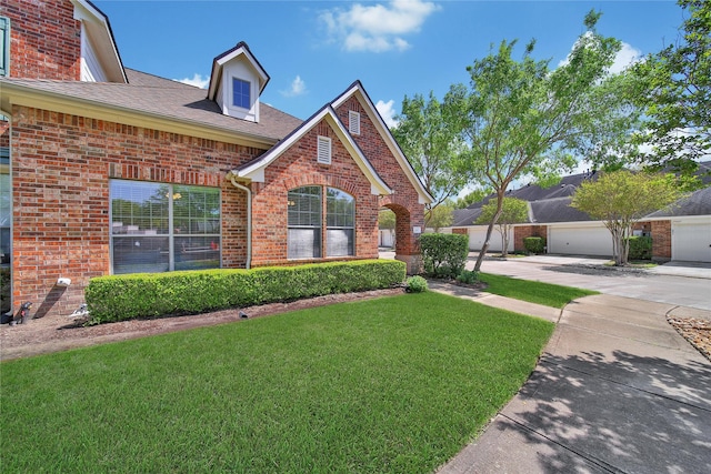 view of front of house with brick siding, a shingled roof, and a front lawn