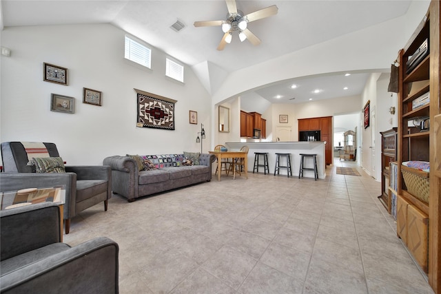 living area with arched walkways, ceiling fan, visible vents, and a wealth of natural light