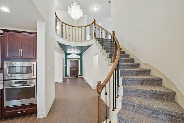 23 Castello Ln, Missouri City, TX 77459 - stairway with baseboards, a high ceiling, an inviting chandelier, and wood finished floors
