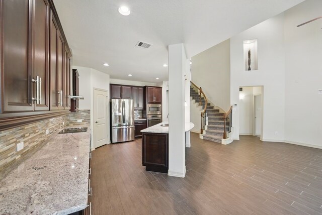 23 Castello Ln, Missouri City, TX 77459 - kitchen with backsplash, stainless steel appliances, dark wood-style flooring, and light stone countertops
