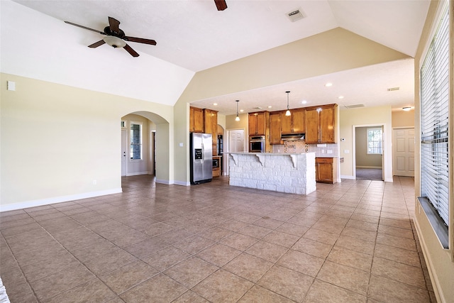 unfurnished living room with ceiling fan, arched walkways, recessed lighting, light tile patterned floors, and lofted ceiling