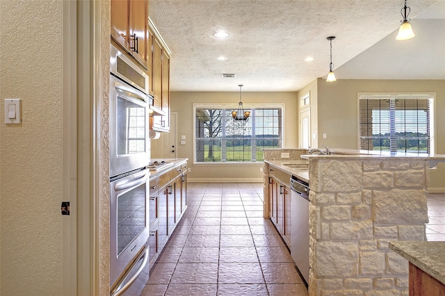 kitchen with appliances with stainless steel finishes, baseboards, and a textured ceiling