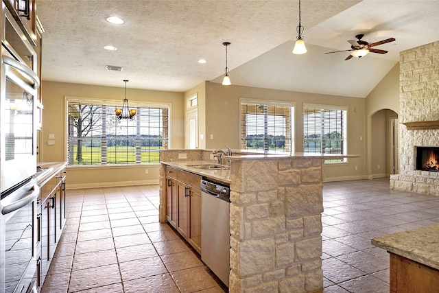 kitchen featuring open floor plan, a sink, a healthy amount of sunlight, and dishwasher