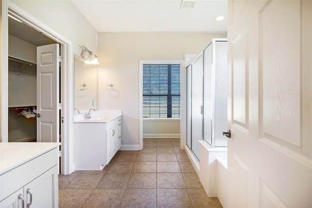 full bathroom featuring tile patterned floors, two vanities, a sink, and a stall shower