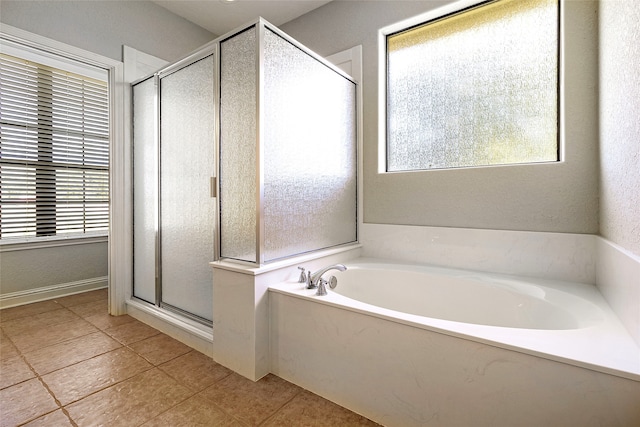 full bathroom with tile patterned floors, a stall shower, a bath, and a wealth of natural light
