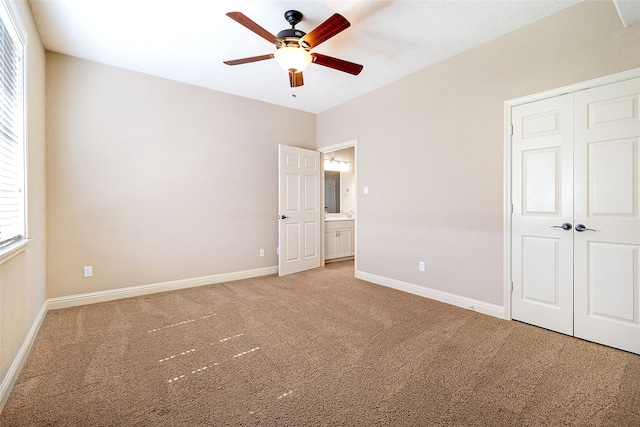 unfurnished bedroom with a closet, baseboards, and light carpet