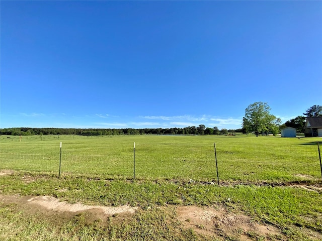 view of yard featuring a rural view and fence