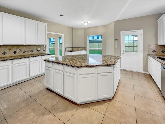 kitchen with white cabinetry, decorative backsplash, light tile patterned floors, and a center island