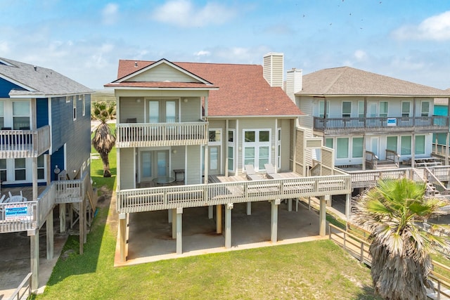 2330 Blue Water Hwy, Surfside Beach, TX 77541 - back of house featuring a lawn, roof with shingles, a balcony, and a chimney