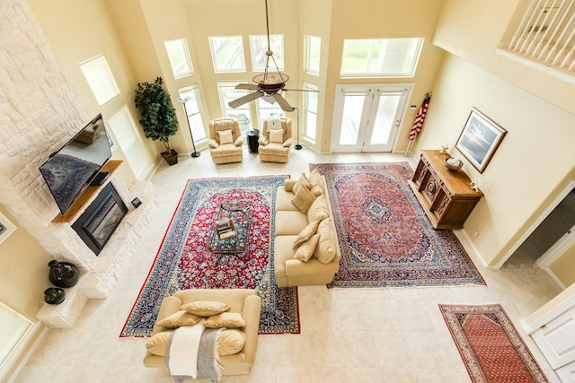 2330 Blue Water Hwy, Surfside Beach, TX 77541 - living room with ceiling fan, a towering ceiling, tile patterned flooring, baseboards, and a glass covered fireplace