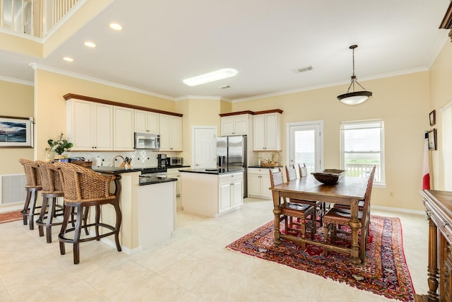 2330 Blue Water Hwy, Surfside Beach, TX 77541 - kitchen featuring dark countertops, appliances with stainless steel finishes, crown molding, and visible vents
