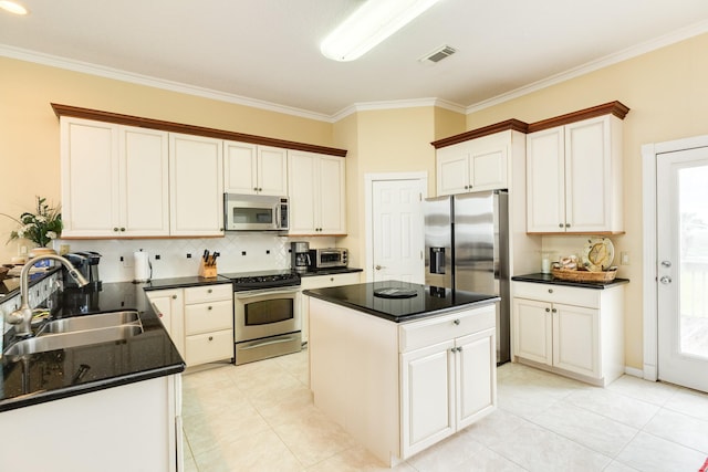 2330 Blue Water Hwy, Surfside Beach, TX 77541 - kitchen featuring visible vents, ornamental molding, tasteful backsplash, a sink, and stainless steel appliances