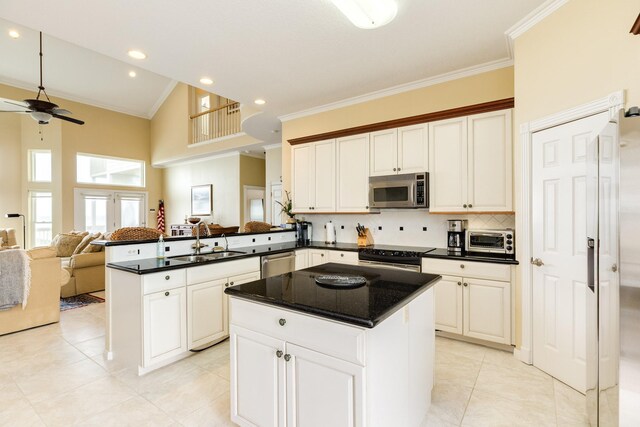 2330 Blue Water Hwy, Surfside Beach, TX 77541 - kitchen with crown molding, appliances with stainless steel finishes, a sink, a peninsula, and open floor plan