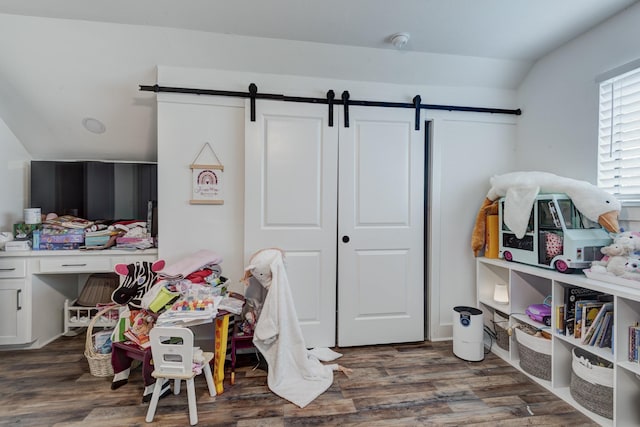 10503 Metronome Dr, Houston, TX 77043 - playroom featuring a barn door, wood finished floors, and vaulted ceiling