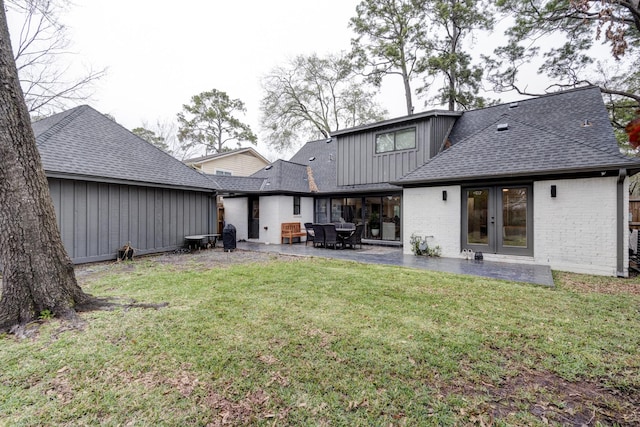 10503 Metronome Dr, Houston, TX 77043 - back of property featuring a shingled roof, brick siding, board and batten siding, a patio area, and a lawn