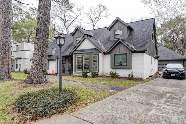 10503 Metronome Dr, Houston, TX 77043 - view of front of home with board and batten siding, a shingled roof, a front lawn, and brick siding
