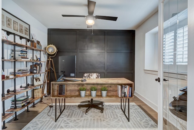 10503 Metronome Dr, Houston, TX 77043 - home office with baseboards, ceiling fan, a decorative wall, and wood finished floors