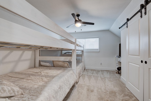 10503 Metronome Dr, Houston, TX 77043 - bedroom with ceiling fan, light colored carpet, vaulted ceiling, a barn door, and baseboards