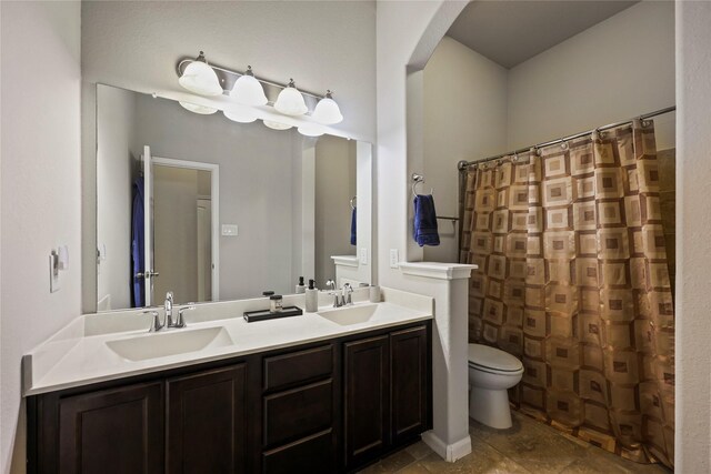 full bath with double vanity, toilet, a shower with shower curtain, and a sink