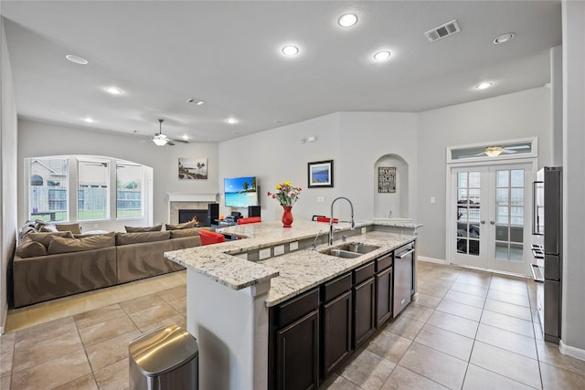10418 Texas Sage Way, Cypress, TX 77433 - kitchen featuring a ceiling fan, stainless steel dishwasher, a lit fireplace, light tile patterned flooring, and recessed lighting