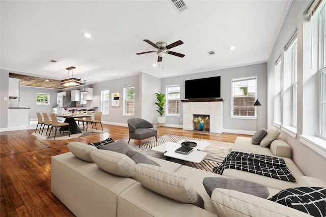 living room featuring baseboards, wood finished floors, and visible vents