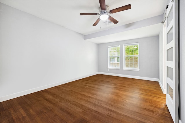 spare room with baseboards, a ceiling fan, wood finished floors, and visible vents