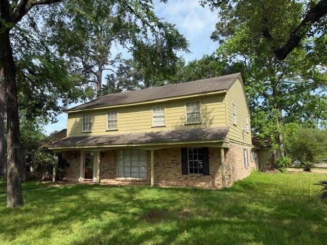 traditional home with brick siding and a front lawn