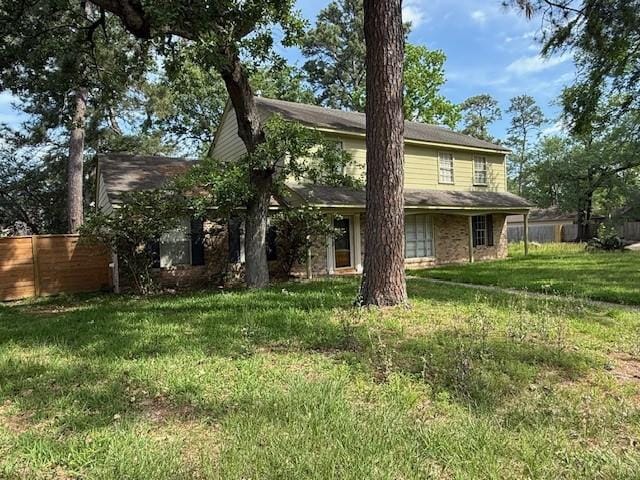 back of house with fence and a lawn