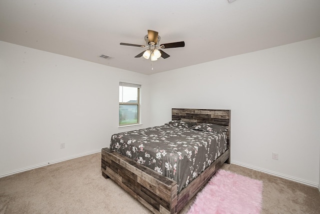 carpeted bedroom with visible vents, baseboards, and ceiling fan