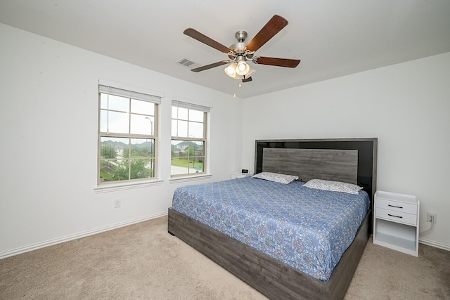 carpeted bedroom featuring a ceiling fan, baseboards, and visible vents