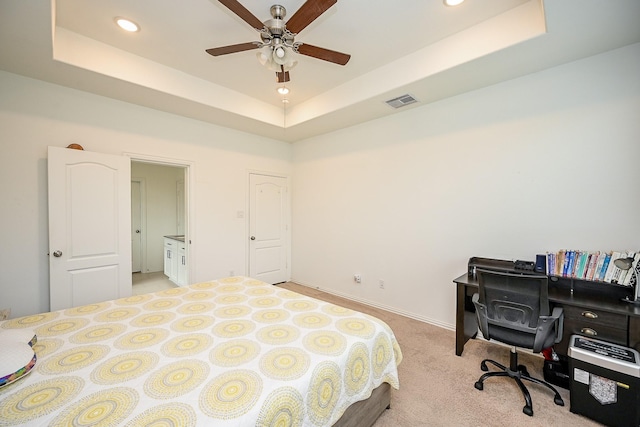 bedroom with light colored carpet, a raised ceiling, recessed lighting, baseboards, and visible vents