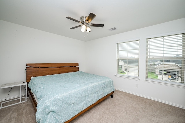 carpeted bedroom with baseboards, ceiling fan, and visible vents