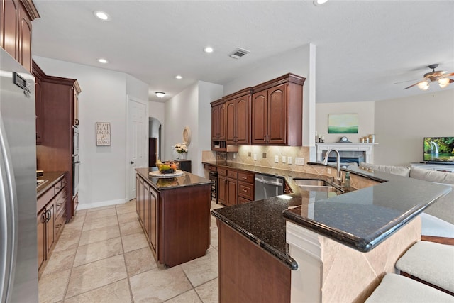17714 W Copper Lakes Dr, Houston, TX 77095 - kitchen featuring appliances with stainless steel finishes, a sink, arched walkways, a center island, and open floor plan