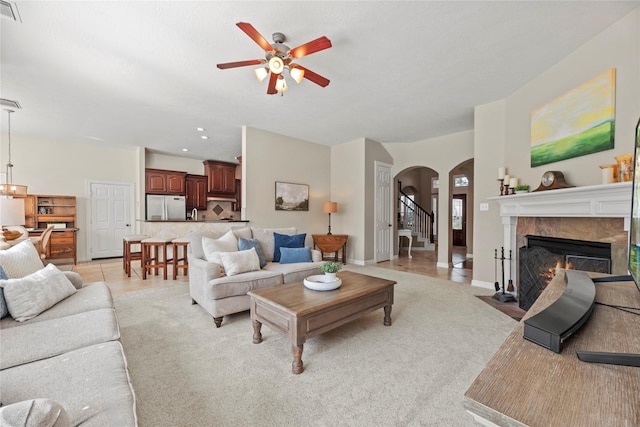 17714 W Copper Lakes Dr, Houston, TX 77095 - living area with ceiling fan, visible vents, arched walkways, a fireplace, and baseboards
